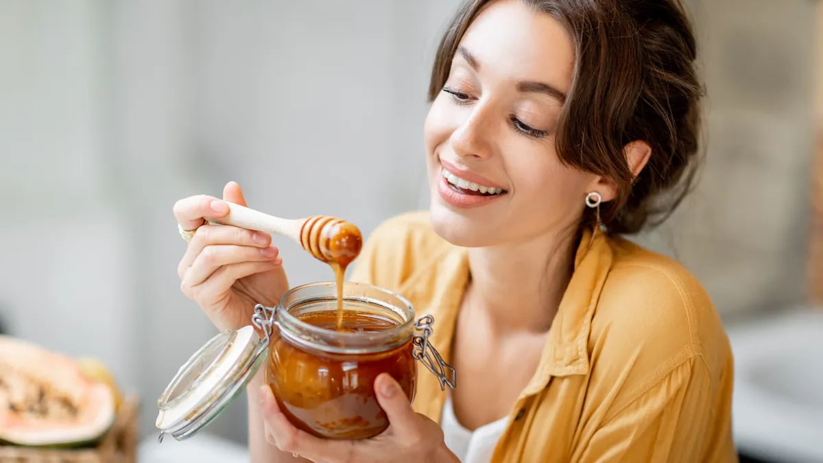 Raw honey flowing from a dipper