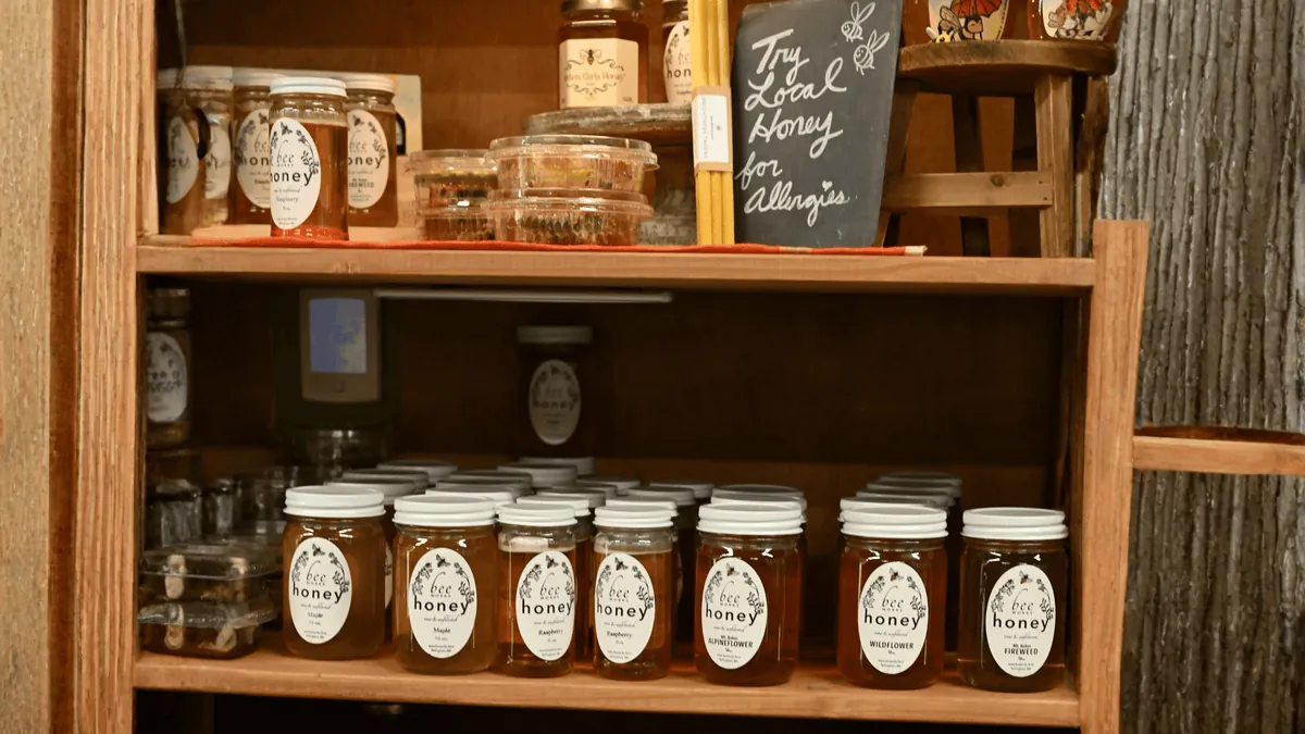 Rows of honey jars on a store shelf
